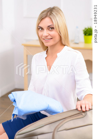 Young lady packing her baggage.  18949231