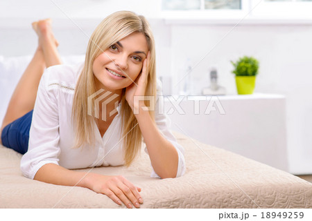 Young lady lying on hotel bed. 18949259