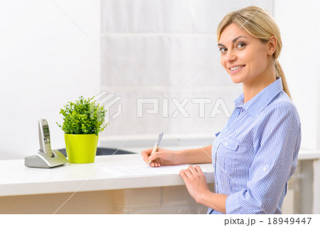 Young lady filling out hotel papers.  18949447
