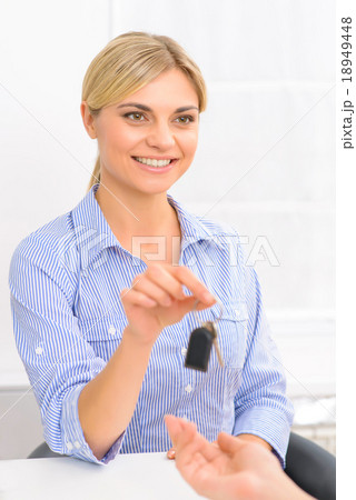 Attractive receptionist offering room key. 18949448
