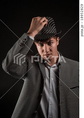 a man in a grey hat on black background 18952829