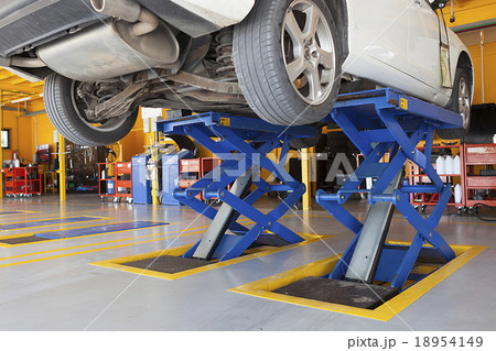 jacks, scissor cranes lift the car in garage 18954149
