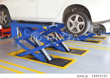 scissor cranes lift white car in garage 18954150