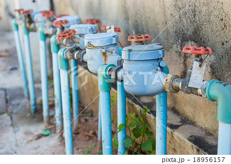 Rusting old water valve with water meter  18956157