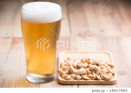 Vintage single glass of beer with cashew nut 18957665