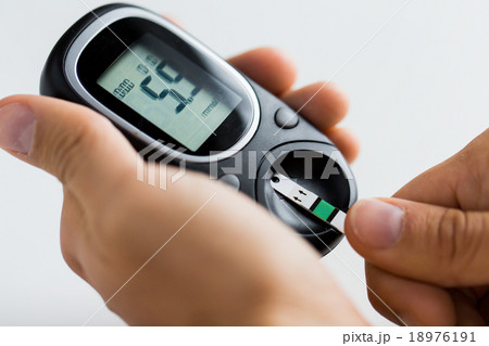close up of man checking blood sugar by glucometer 18976191