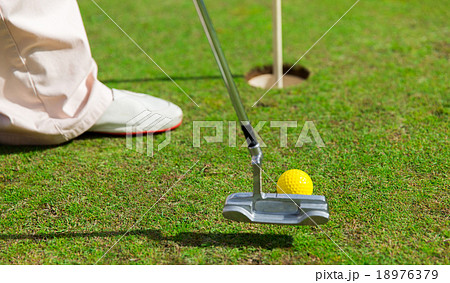 close up of man with club and ball playing golf 18976379