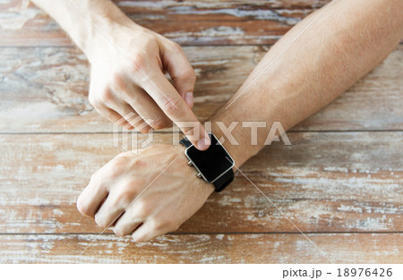 close up of male hands setting smart watch 18976426