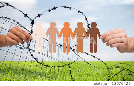 hands holding people pictogram over barb wire hands holding people pictogram over barb wire 18976429