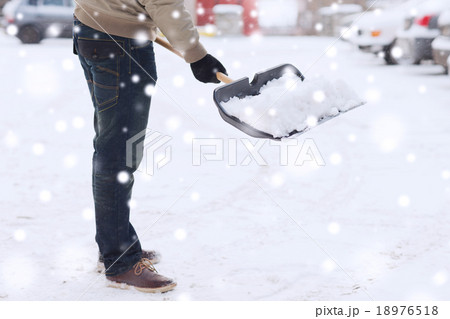 closeup of man digging snow with shovel near car 18976518