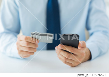 close up of hands with smart phone and credit card 18976523