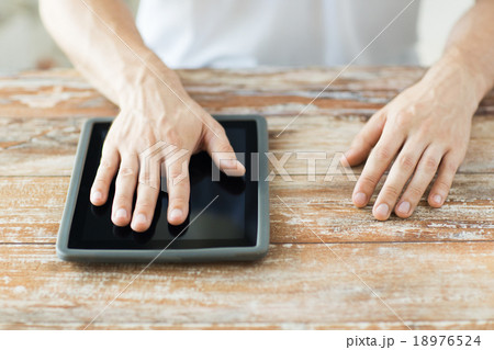 close up of male hands with tablet pc on table 18976524