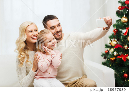 family taking selfie with smartphone at christmas family taking selfie with smartphone at christmas 18977089
