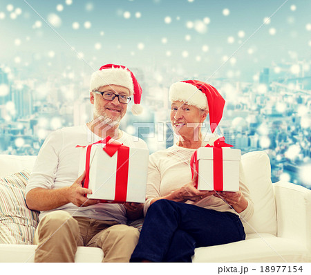 happy senior couple in santa hats with gift boxes 18977154