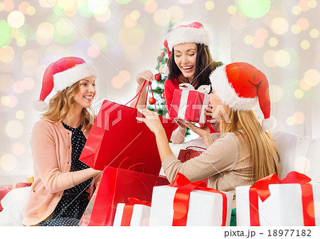 happy women in santa hats with christmas gifts happy women in santa hats with christmas gifts 18977182
