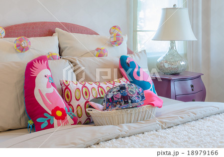 colorful hat in basket with pillows on kid's bed 18979166