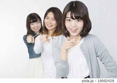 若い女性 3人 カメラ目線で指差す ポーズ の写真素材