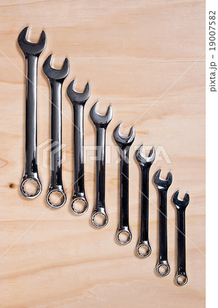Metallic wrench on the wooden background 19007582