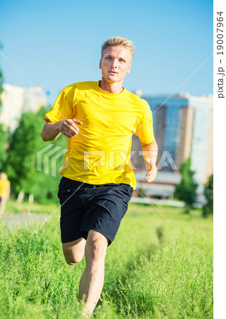 Sporty man jogging in city street park. Outdoor 19007964
