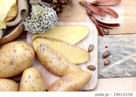 Potato chip and fresh potatoes on wood background Potato chip and fresh potatoes on wood background 19013556