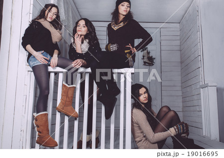 Four stylish models posing sitting on the fence Four stylish models posing sitting on the fence 19016695
