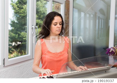 Female musician playing sequencer Female musician playing sequencer 19019337