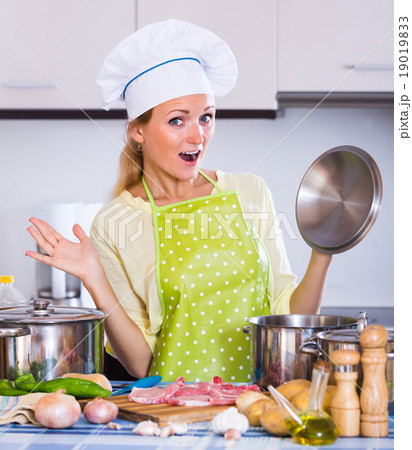 Young woman cooking meat at home. 19019833