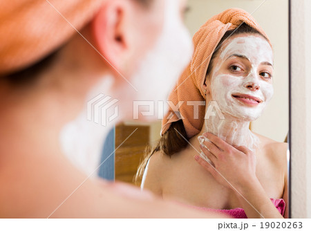 Girl applying cream on skin 19020263