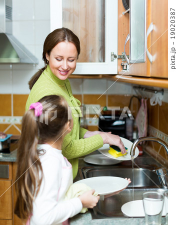 girl with mother washing dishes 19020387