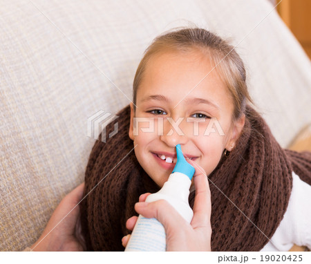 Woman treating daughter for rhinitis 19020425