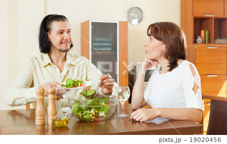 beautiful woman with man eating veggie salad at home beautiful woman with man eating veggie salad at home 19020456