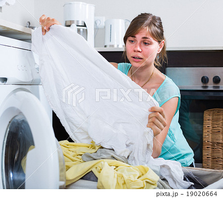 woman with dirty linen near washing machine woman with dirty linen near washing machine 19020664