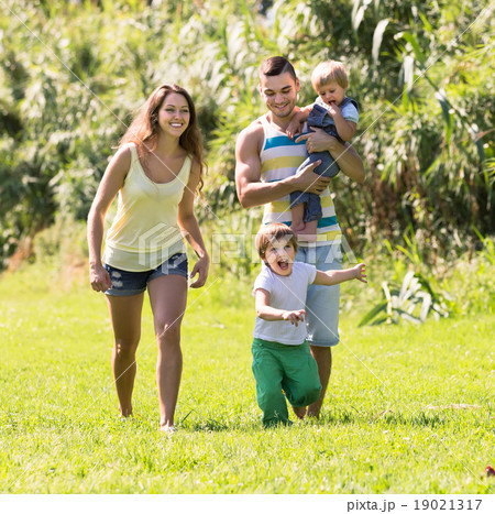 Family of four in sunny park Family of four in sunny park 19021317