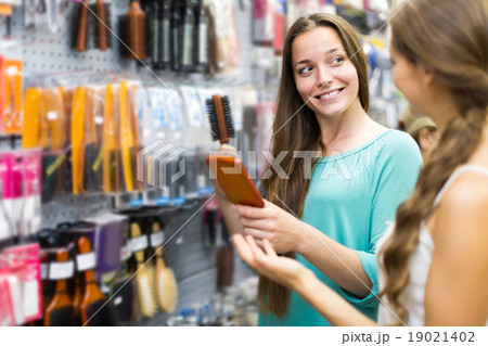 girl buying hairbrush in shopping mall girl buying hairbrush in shopping mall 19021402