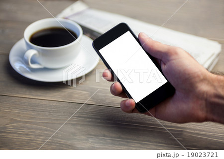 Person showing mobile phone at desk 19023721