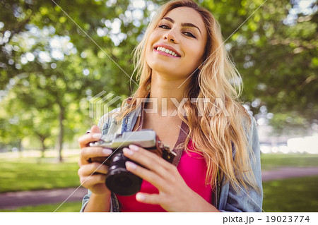 Portrait of happy woman holding camera Portrait of happy woman holding camera 19023774