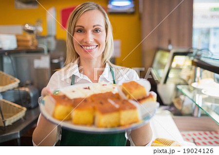 Happy female worker serving pastries Happy female worker serving pastries 19024126