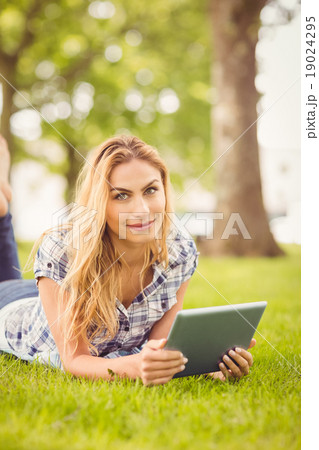 Portrait of smiling woman holding digital tablet at park Portrait of smiling woman holding digital tablet at park 19024295