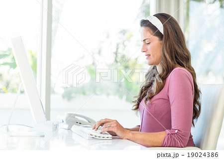 Side view of businesswoman typing on keyboard 19024386