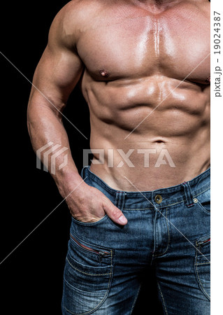 Midsection of shirtless man with hands in pocket 19024387