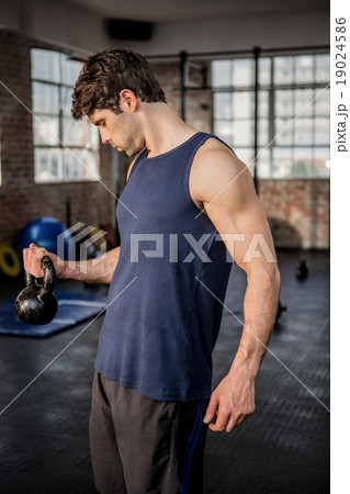 Muscular man lifting kettlebell Muscular man lifting kettlebell 19024586