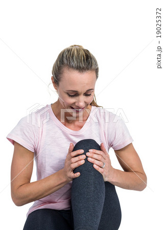 Sporty woman massaging knee Sporty woman massaging knee 19025372