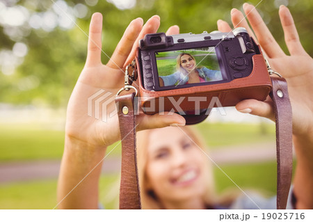 Smiling woman taking self portrait 19025716