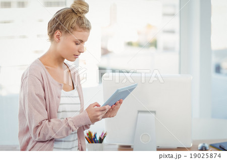 Woman using digital tablet in office Woman using digital tablet in office 19025874