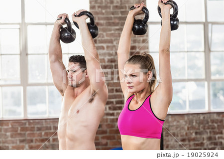 muscular serious couple with kettlebells muscular serious couple with kettlebells 19025924