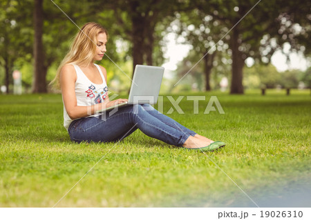 Full length of confident woman using laptop at park Full length of confident woman using laptop at park 19026310