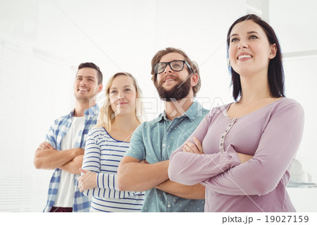 Smiling business people standing in row with arms crossed 19027159