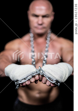 Portrait of confident man with bandage and chain Portrait of confident man with bandage and chain 19027236