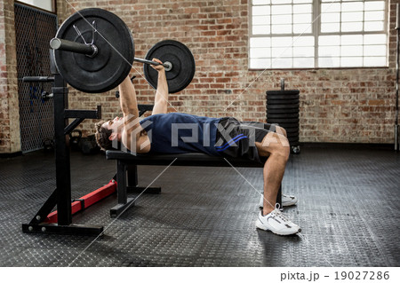Side view of a man lifting barbell Side view of a man lifting barbell 19027286