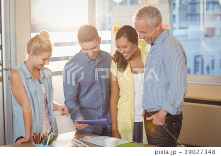 Business people looking at digital tablet in meeting room 19027348